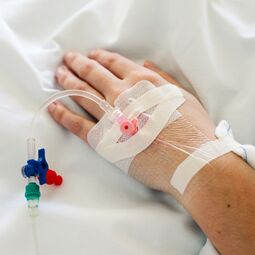 Perfusion intraveineuse insérée dans la main de la femme.