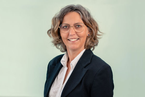 Portrait of Astrid Margrethe Hilde, looking at the camera smiling against an outdoors background.