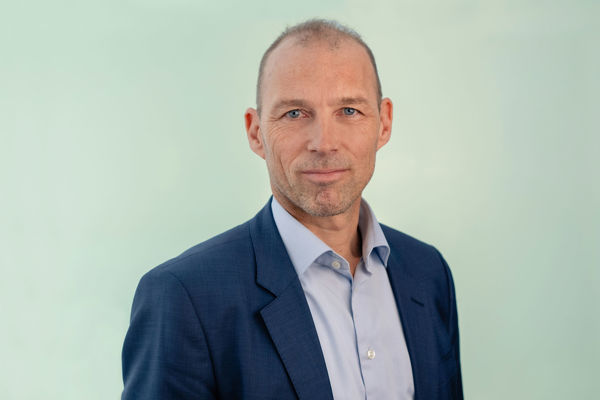 Portrait of Christian Must, looking at the camera with a neutral expression against a plain background.
