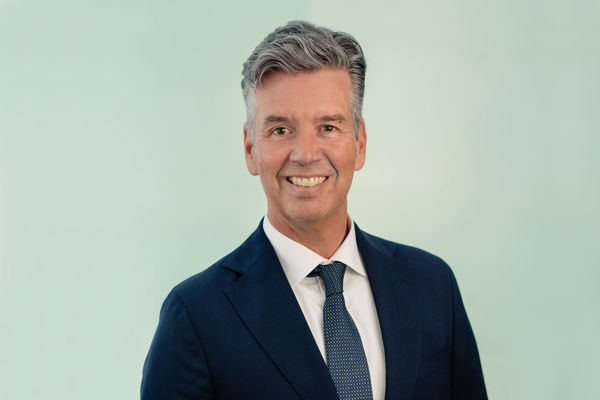 Portrait of Richard Olav Aa, looking at the camera, smiling, against a plain background.